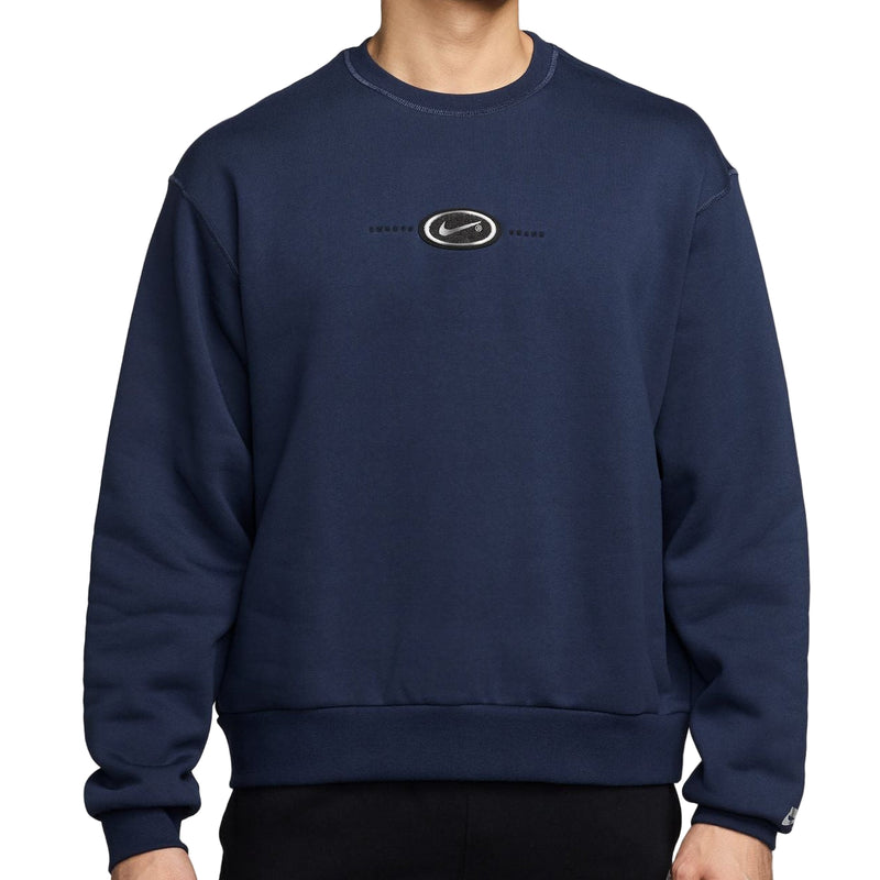Man wearing a navy blue sweatshirt with a logo on a white background