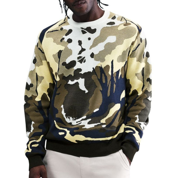 Person wearing a camouflage sweater and white pants on a white background