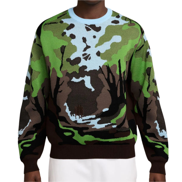 Person wearing a camouflage-patterned sweatshirt on a white background
