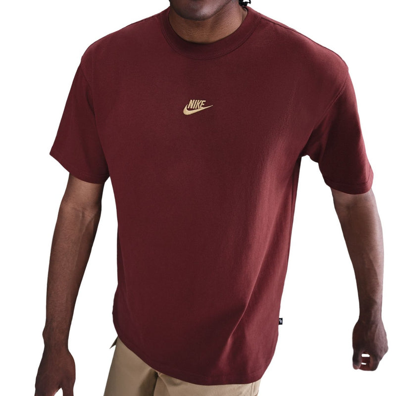 Person wearing a maroon t-shirt with a Nike logo on a white background