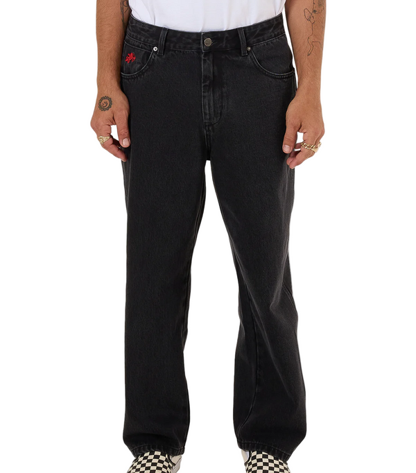 Person wearing black jeans and checkered shoes on a white background