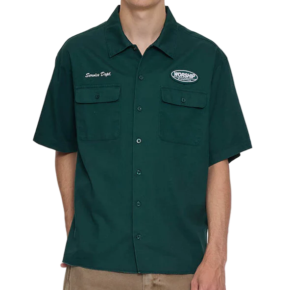 Person wearing a green work shirt with logos on a white background