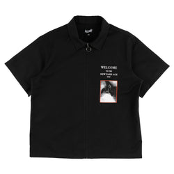 Black polo shirt with graphic design and text on a white background