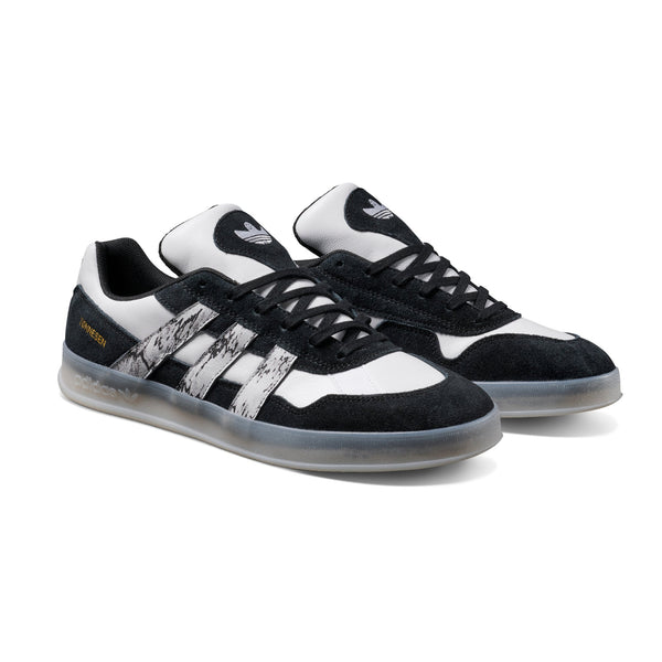 Black and white sneakers with a brand logo on a white background
