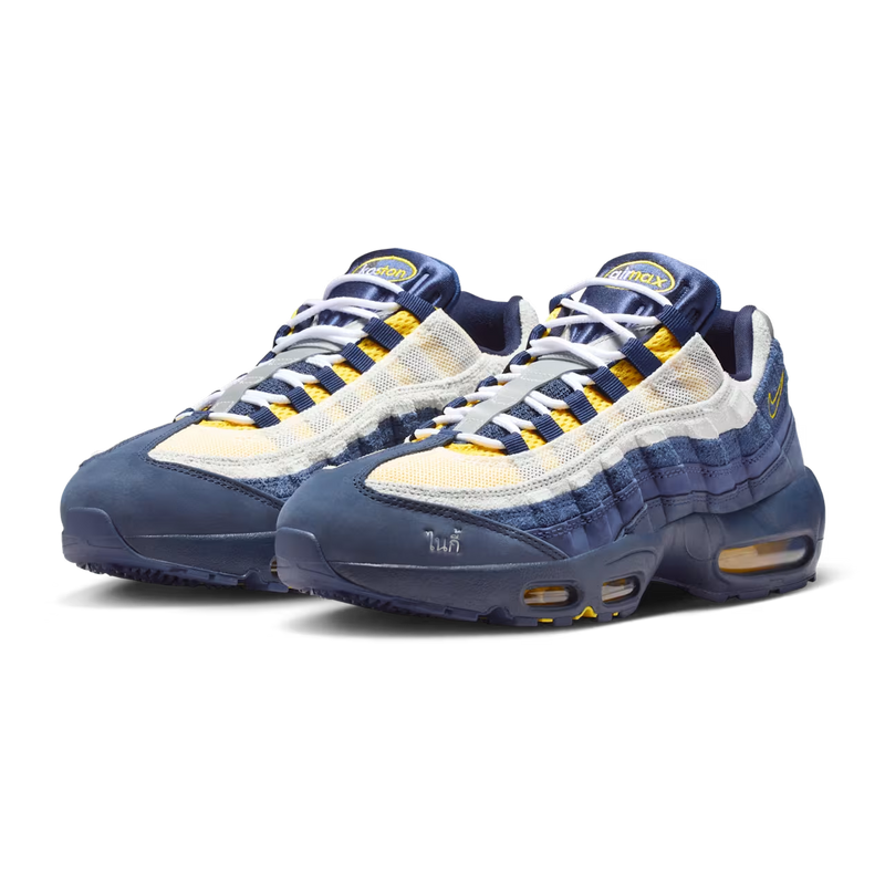 Pair of blue and white sneakers with yellow accents on a white background